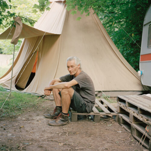 "Fred" sitzt auf einer Palette vor dem Tipi in Lützerath, in dem er oft die Nacht verbringt. Gemeinsam mit vielen anderen Aktivisten vor Ort setzt er sich für den Erhalt des Dorfes ein.